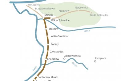 Mapa przedstawia schemat linii kolejowych z różnokolorowymi trasami i nazwami stacji. Kolory linii to błękitny i niebieski, które krzyżują się w kilku punktach, symbolizując różne trasy pociągów. Wokół mapy widać nazwy miejscowości, a całość ma charakter uproszczonej sieci komunikacyjnej.