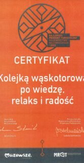 Na pomarańczowym tle znajduje się czarny nadruk, który zawiera grafikę przypominającą koło z wieloma szprychami oraz tekst. Nadrukowany tekst to tytuł "Kolejką wąskotorową po wiedzę, relaks i radość" oraz nazwy organizacji, które przyznały certyfikat: "Mazowsze", "MRoT". Certyfikat jest podpisany i zawiera logo organizacji.