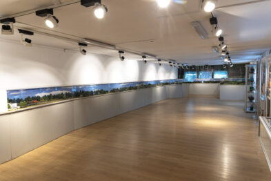 W przestronnej sali na ścianie umieszczona jest długa, panoramiczna makietą kolejową przedstawiająca krajobraz z torami i modelami pociągów. Sala posiada drewnianą podłogę i jest dobrze oświetlona za pomocą wielu punktowych świateł sufitowych. Z prawej strony znajduje się niewielkie stanowisko z ekranem i innym wyposażeniem, które wydaje się być częścią wystawy interaktywnej.