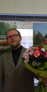 Autor wystawy Tomasz Jankowski widoczny z kwiatami
