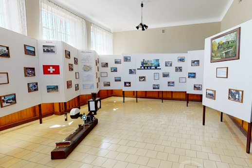 Sala ze ścianką wystawienniczą, na której umieszczone są fotografie