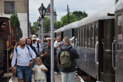 Muzealny pociąg wjeżdża w peron, na którym stoją turyści
